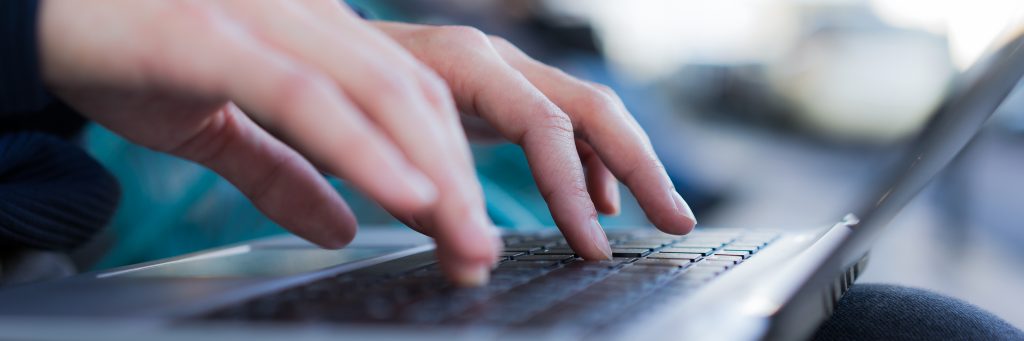 A picture of someone typing on his computer